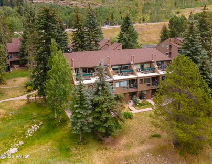 an aerial view of a house with swimming pool and lake view