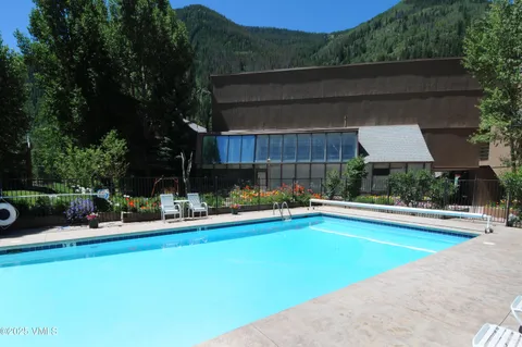 a view of a swimming pool with a patio and plants