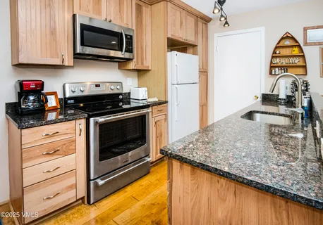 a kitchen with stainless steel appliances granite countertop a stove a microwave and a refrigerator