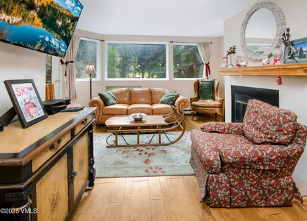 a living room with furniture a fireplace and a large window