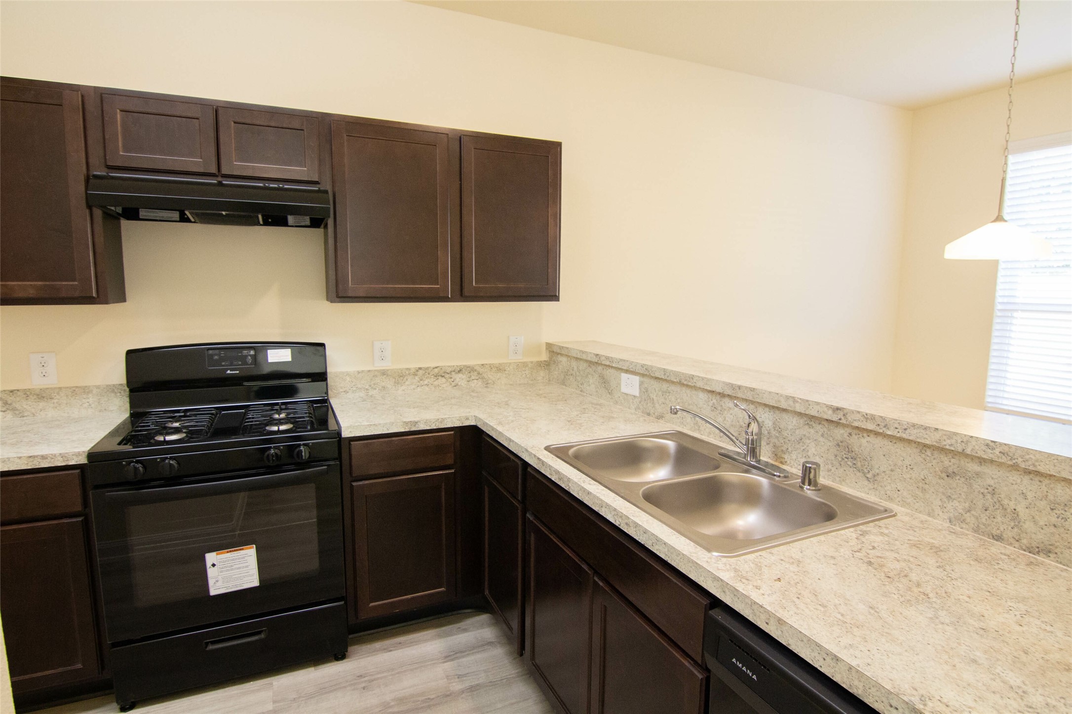 12738 Veterans Silver Road Houston, TX 77014 - Photo 3 of 12 a kitchen with granite countertop a stove sink and cabinets
