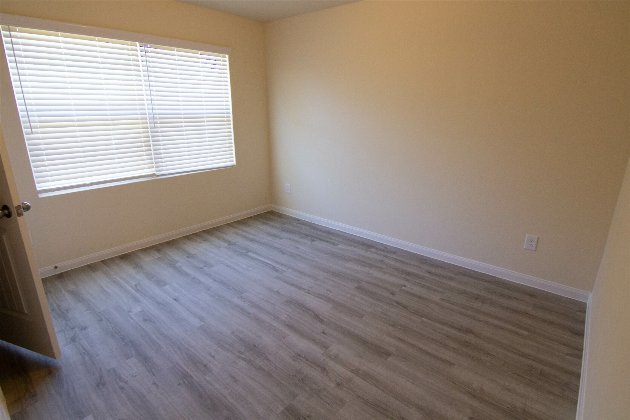 12738 Veterans Silver Road Houston, TX 77014 - Photo 7 of 12 an empty room with wooden floor and windows