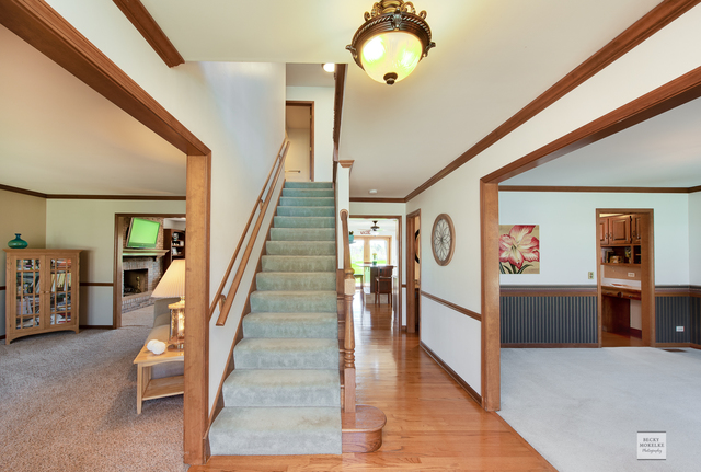 1812 Denison Road Naperville, IL 60565 - Photo 3 of 33 a view of a hallway with wooden floor and staircase