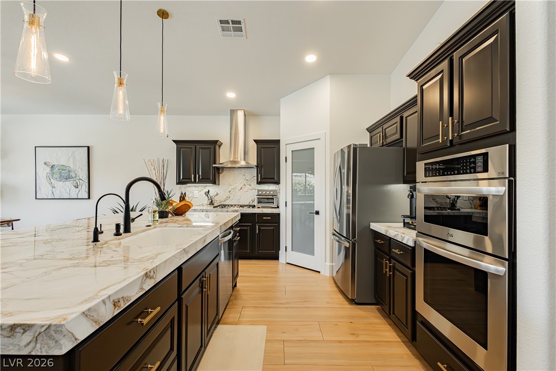 2256 Dogwood Ranch Avenue Henderson, NV 89052 - Photo 20 of 51 Marble countertops and rich cabinetry define this culinary space, offering both elegance and functionality.