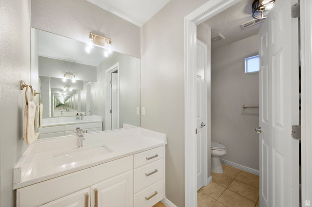 1440 West 100 South Virgin, UT 84779 - Photo 26 of 45 Bathroom vanity featuring a light-toned countertop, integrated sink, and white cabinetry with brushed gold hardware