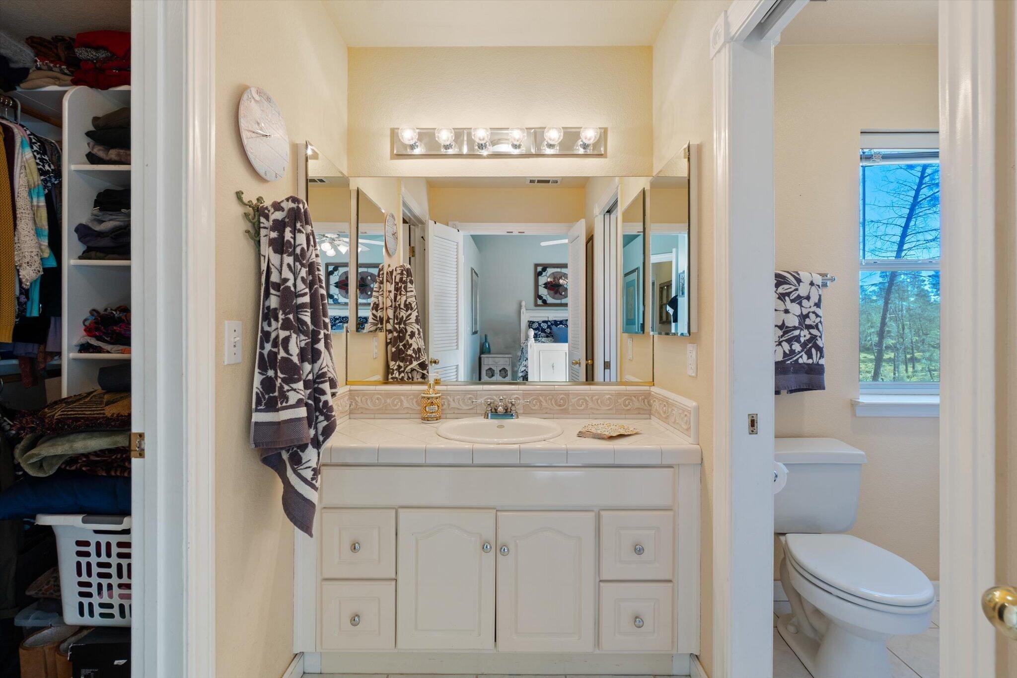 10067 Tilton Mine Road Redding, CA 96001 - Photo 13 of 62 a bathroom with a sink vanity mirror and toilet