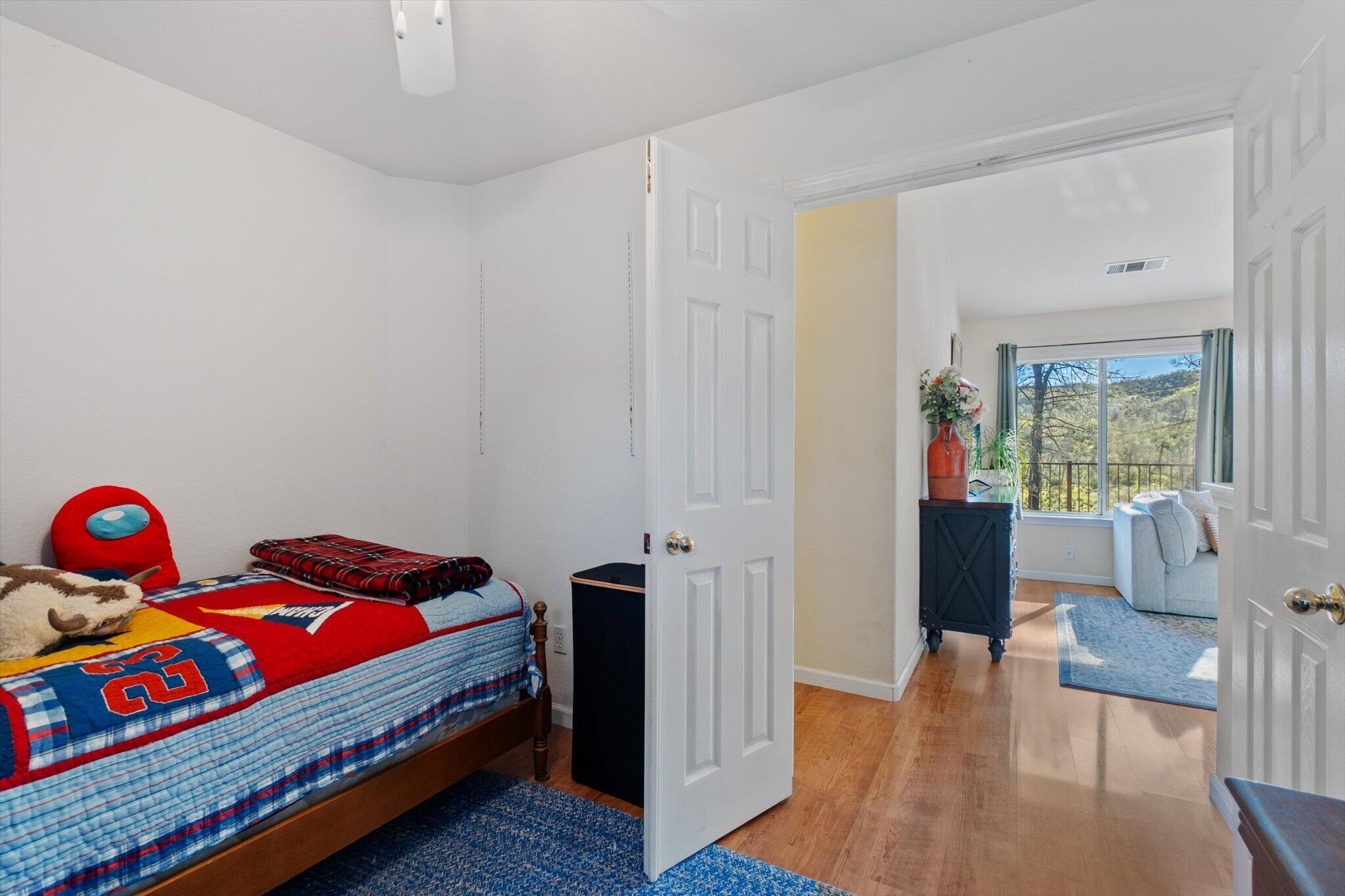 10067 Tilton Mine Road Redding, CA 96001 - Photo 20 of 62 a bedroom with a bed and wooden floor