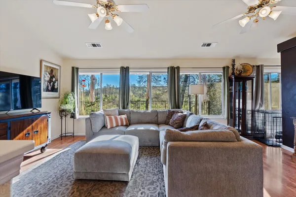 a living room with furniture a flat screen tv and a large window