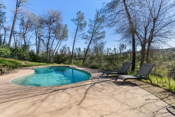 a view of a house with a big yard plants and large trees