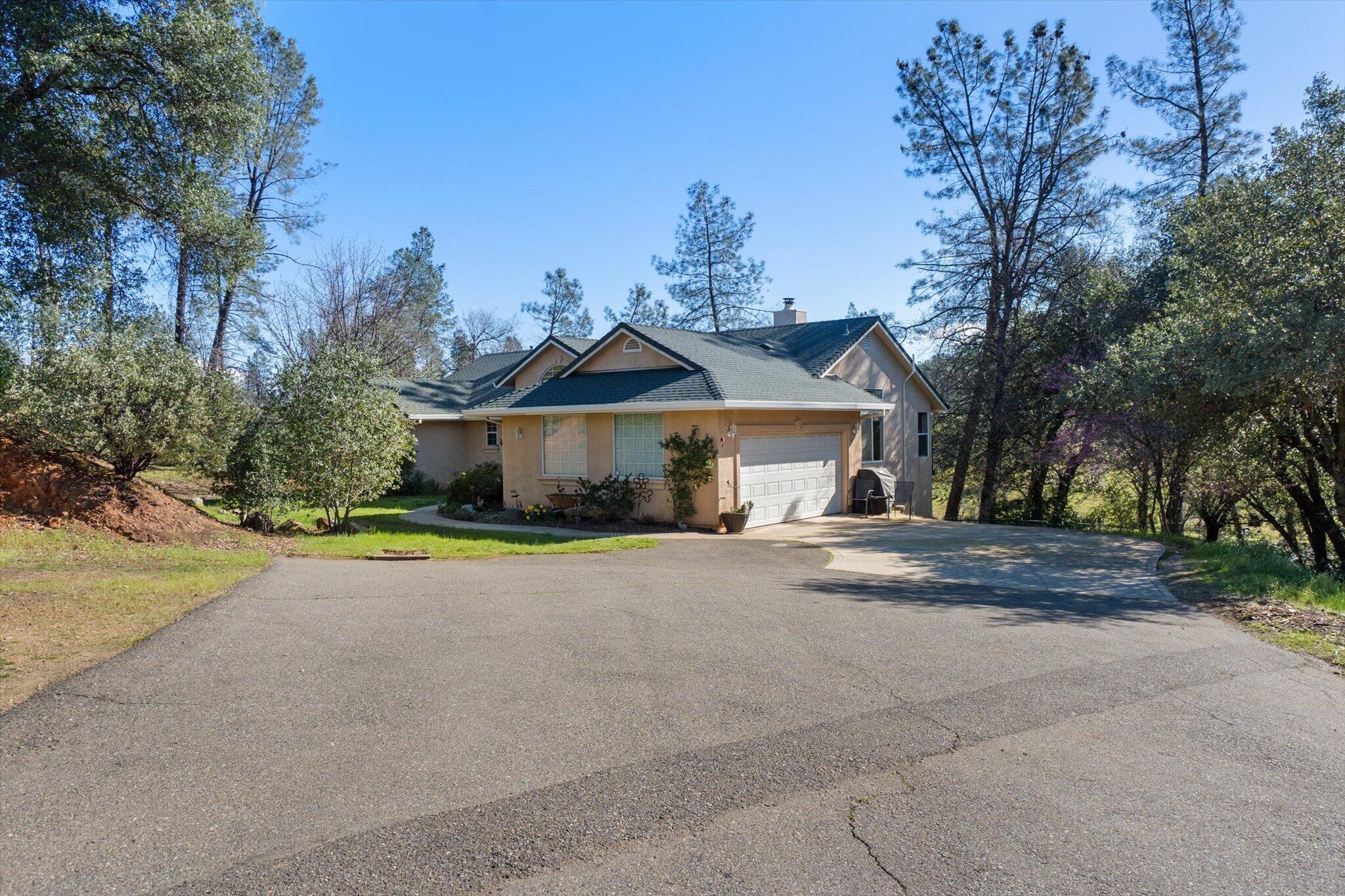 10067 Tilton Mine Road Redding, CA 96001 - Photo 44 of 62 a front view of a house with a yard and garage