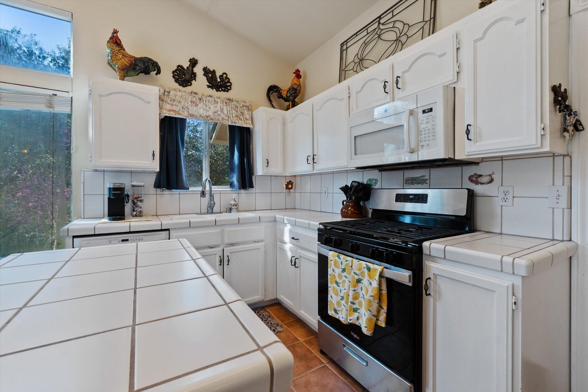 10067 Tilton Mine Road Redding, CA 96001 - Photo 6 of 62 a kitchen with granite countertop a sink a stove and cabinets