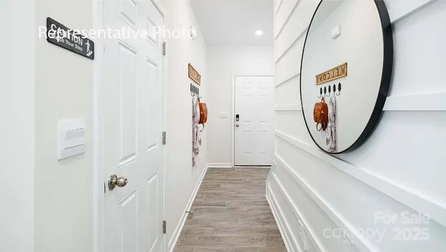 a view of a hallway with wooden floor and entryway