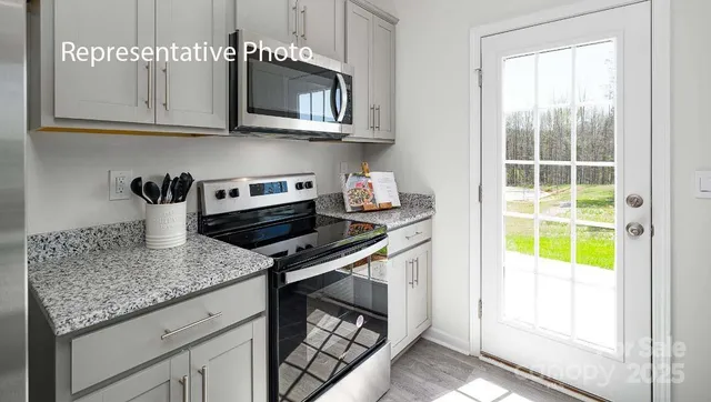 a kitchen with stainless steel appliances granite countertop a stove and a microwave