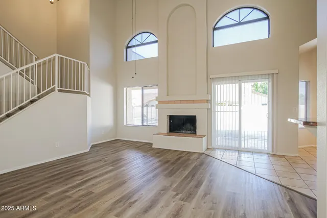 a view of a livingroom with wooden floor and staircase