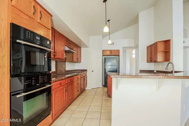 a large kitchen with stainless steel appliances granite countertop a stove a sink and a microwave