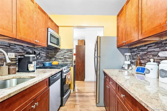 a kitchen with stainless steel appliances granite countertop a sink and a refrigerator
