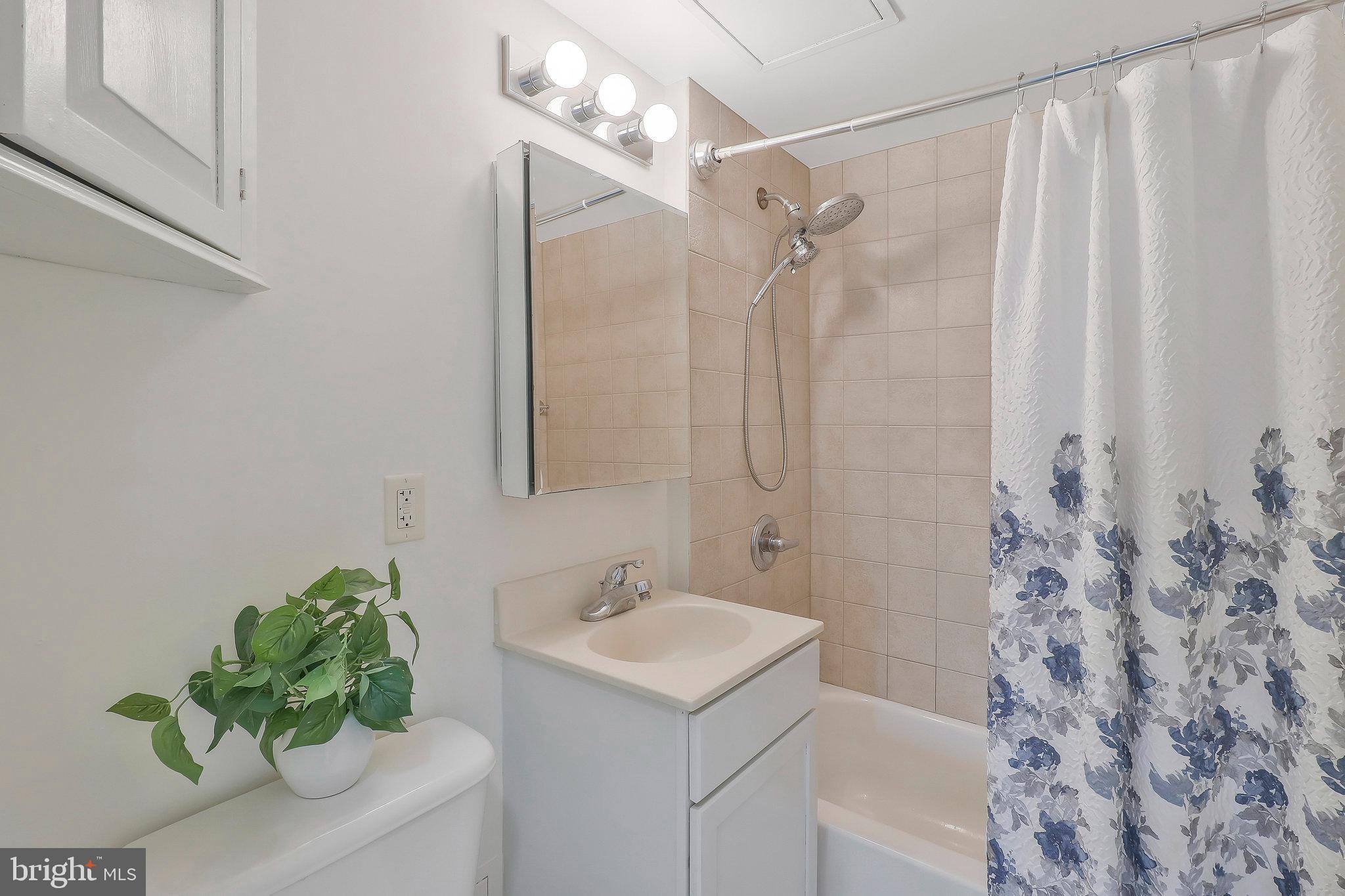 800 4th Street Southwest, Unit S721 Washington, DC 20024 - Photo 21 of 39 a bathroom with a sink a mirror and a shower curtain