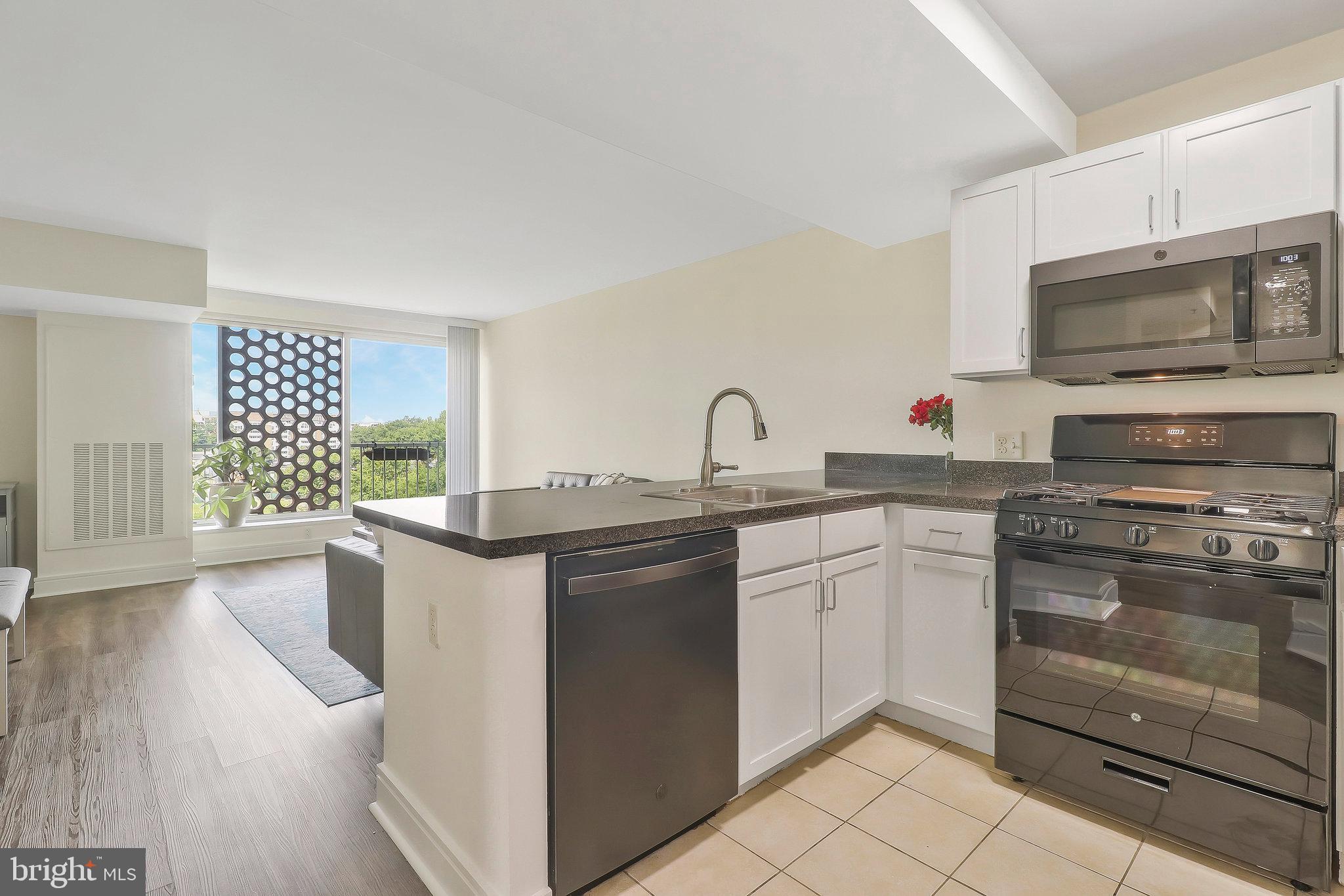 800 4th Street Southwest, Unit S721 Washington, DC 20024 - Photo 8 of 39 a kitchen with stainless steel appliances granite countertop a stove a sink and a microwave