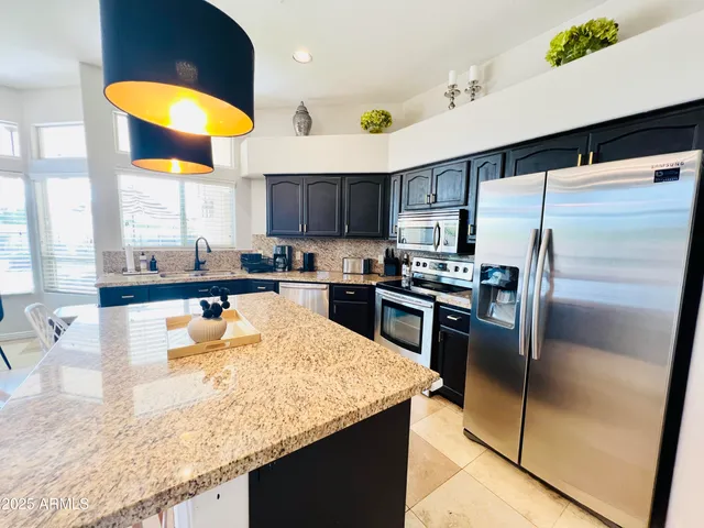 a kitchen with stainless steel appliances granite countertop a sink a stove and a refrigerator