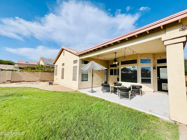 a view of a patio with table and chairs under an umbrella