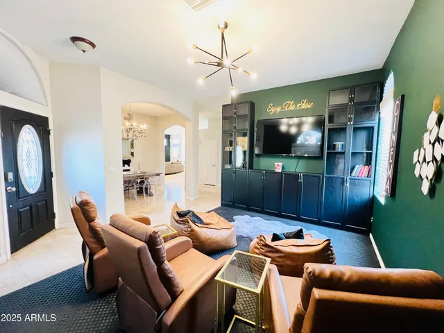 a living room with furniture a flat screen tv and kitchen view