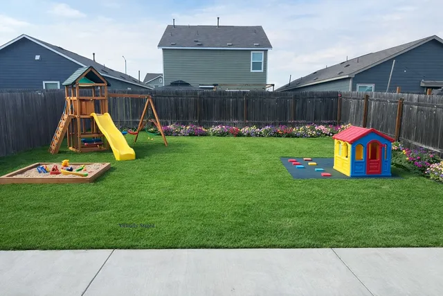 a view of backyard with small play house and slide