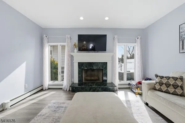 a living room with furniture a flat screen tv and a fireplace