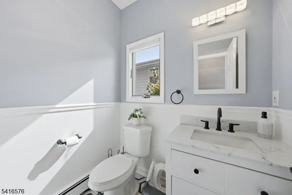 a bathroom with a sink a toilet a mirror and shower