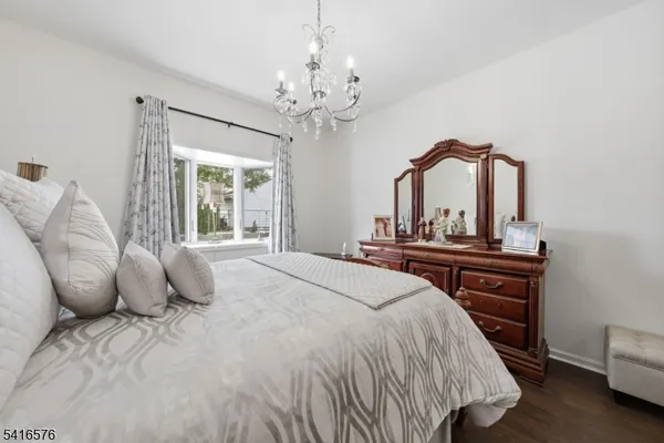 a bedroom with a bed and a large mirror on the dresser