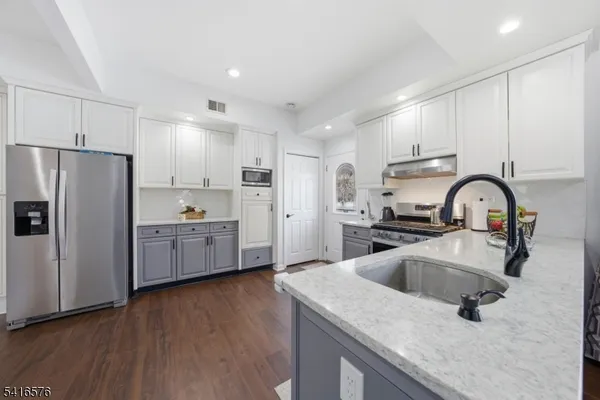 a kitchen with a refrigerator sink and cabinets