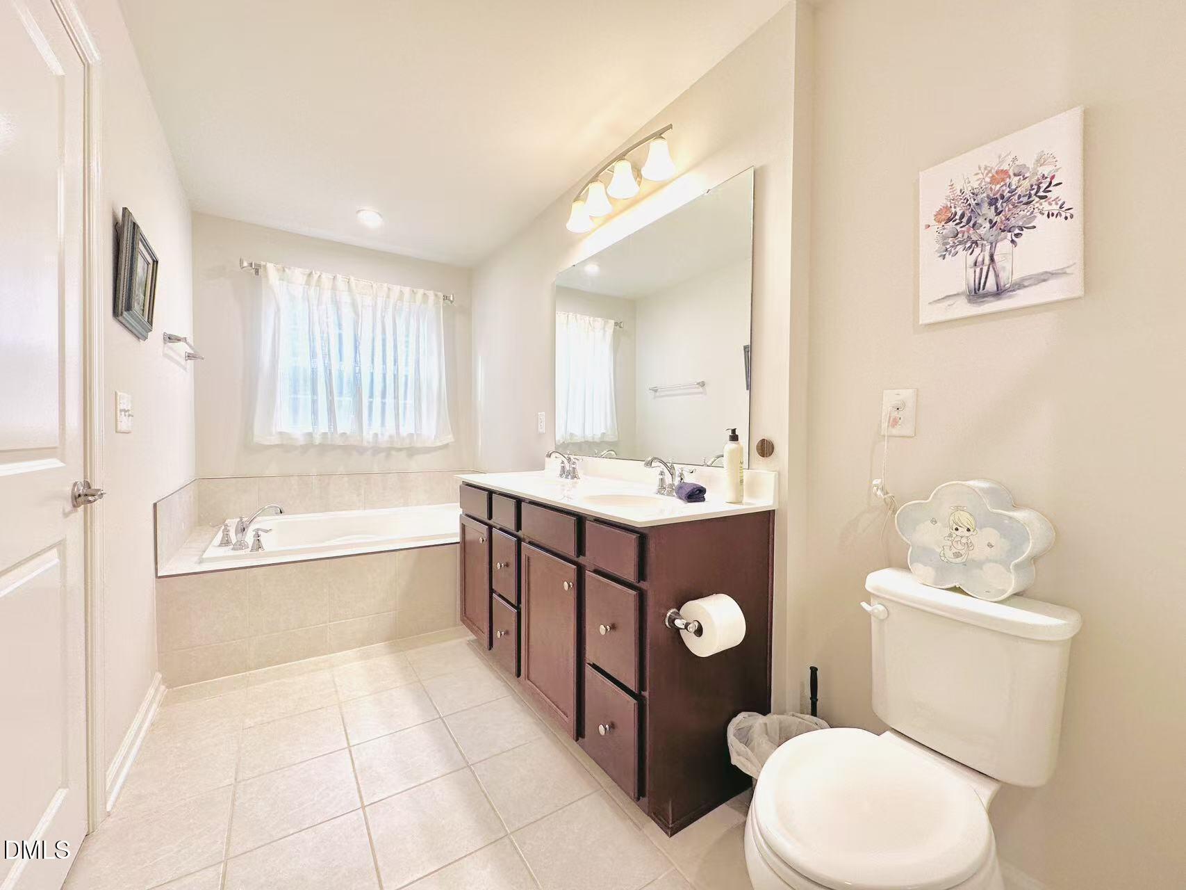 4740 Randall Road Durham, NC 27707 - Photo 12 of 29 a bathroom with a tub a toilet a sink and mirror