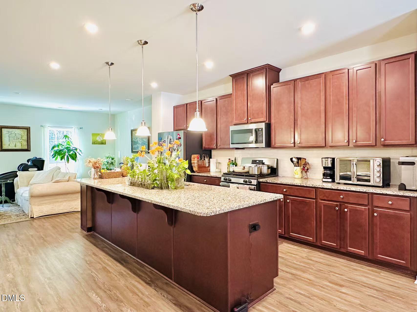 4740 Randall Road Durham, NC 27707 - Photo 2 of 29 a large kitchen with stainless steel appliances granite countertop a sink a stove and a wooden floors