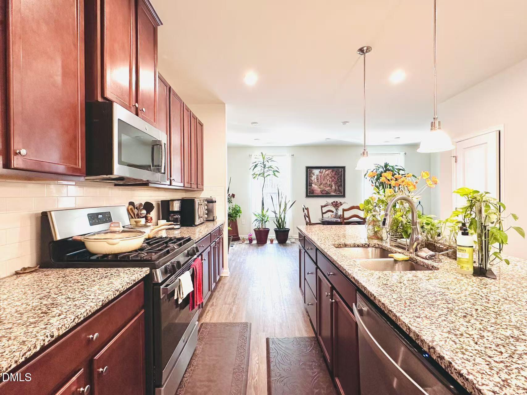 4740 Randall Road Durham, NC 27707 - Photo 4 of 29 a kitchen with stainless steel appliances granite countertop a sink a stove and a wooden floors