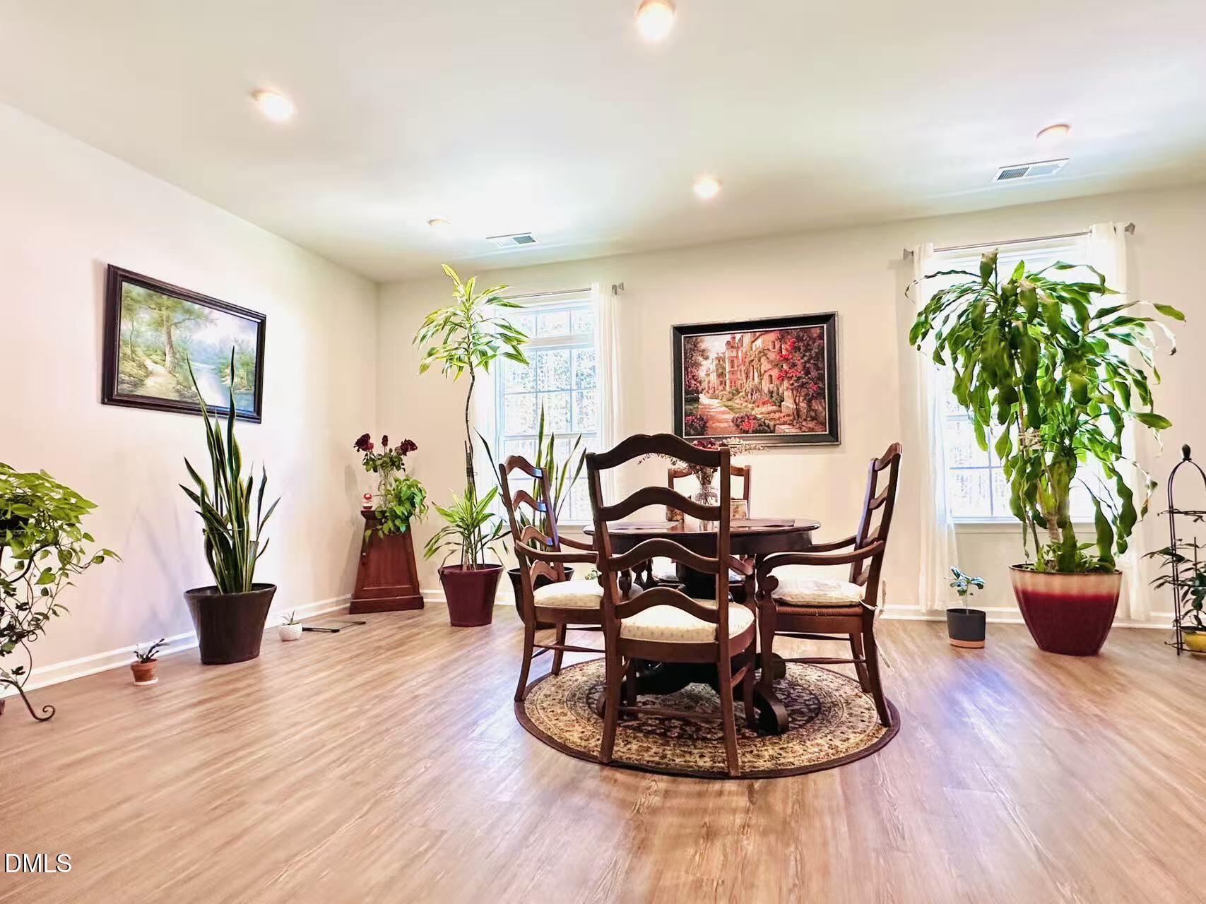 4740 Randall Road Durham, NC 27707 - Photo 8 of 29 a dining room with furniture potted plants and wooden floor