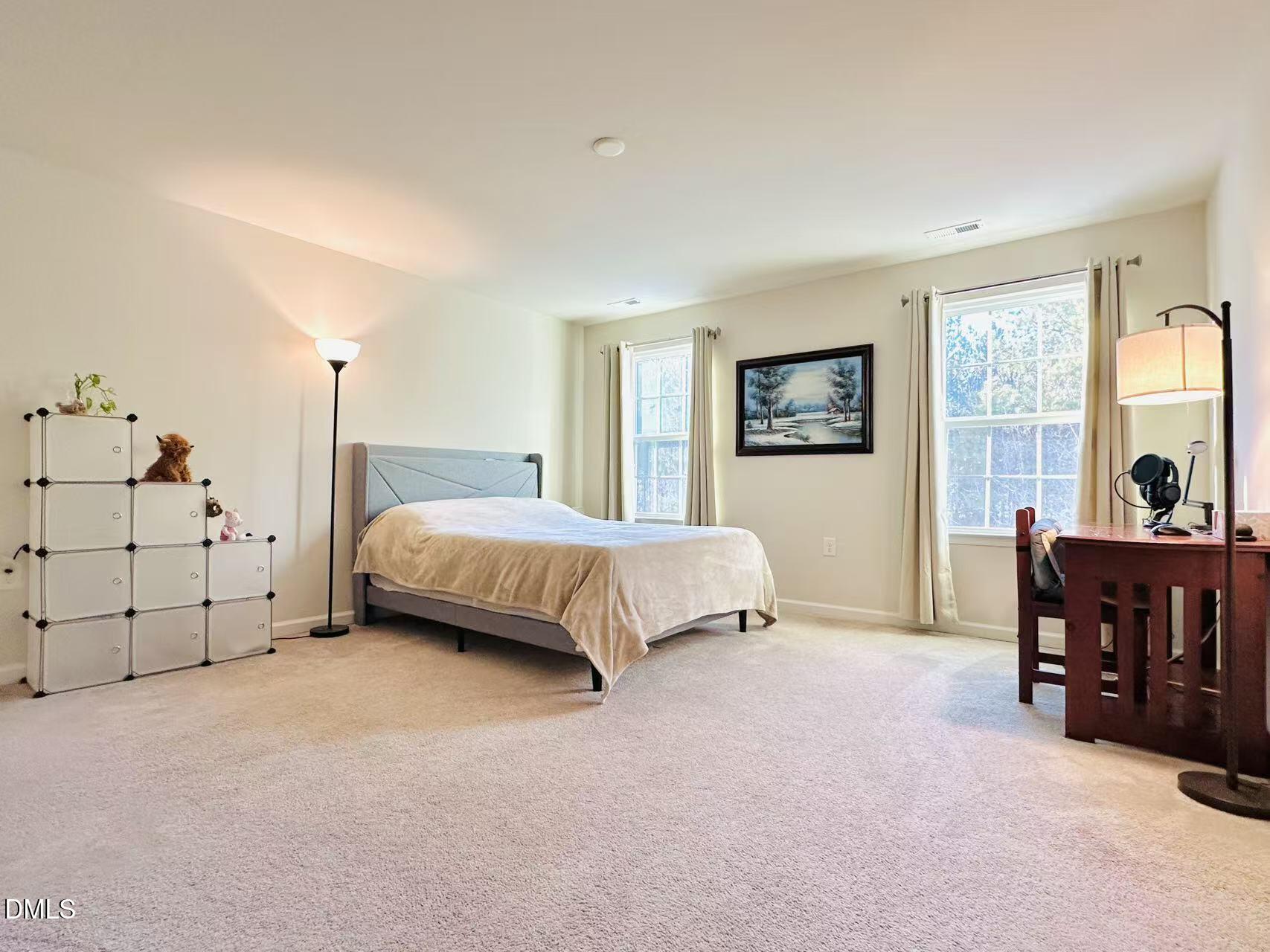 4740 Randall Road Durham, NC 27707 - Photo 10 of 29 a spacious bedroom with a bed and a table in it