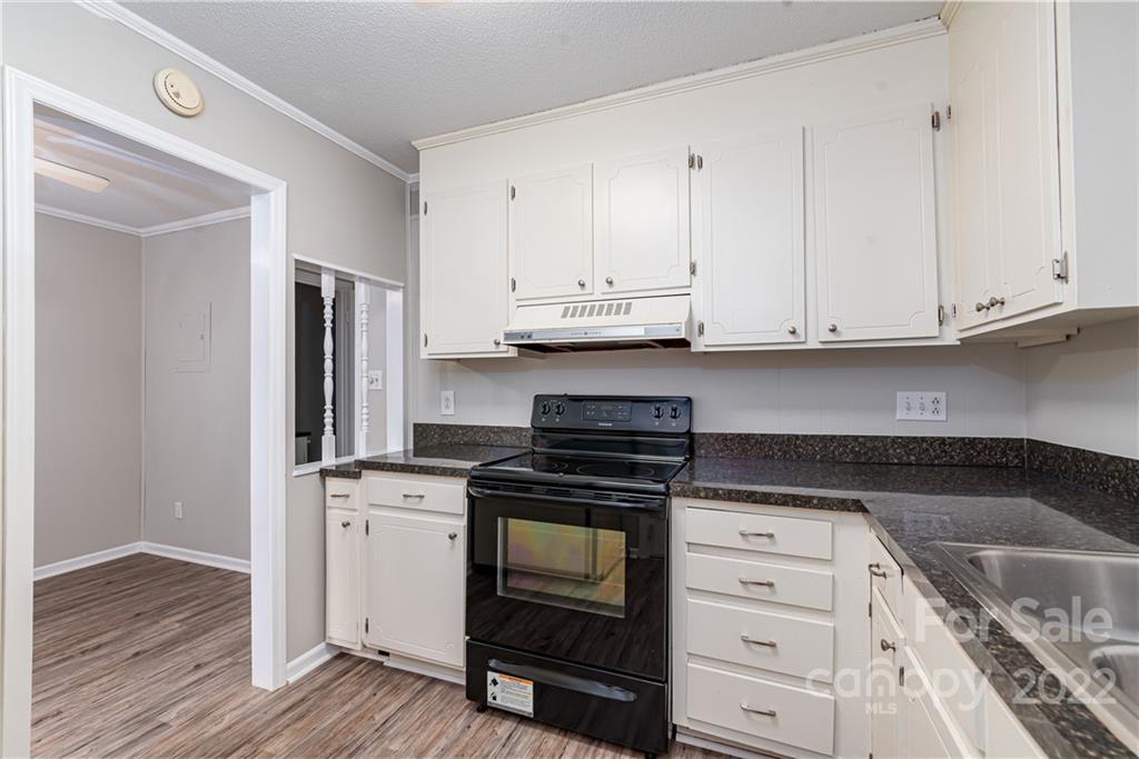 623 South New Hope Road, Unit 21 Gastonia, NC 28054 - Photo 9 of 18 a kitchen with granite countertop white cabinets and stainless steel appliances