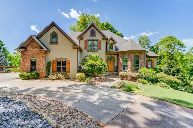 a front view of a house with a yard and potted plants