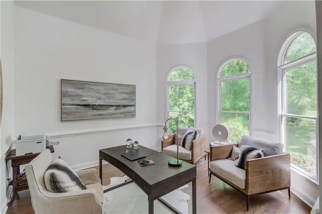 a dining room with wooden floor a chandelier a wooden table and chairs