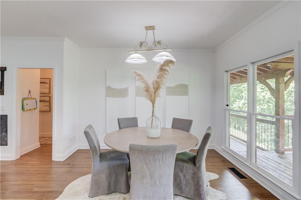 2870 Roanoke Road Cumming, GA 30041 - Photo 24 of 94 a dining room with wooden floor a chandelier a wooden table and chairs