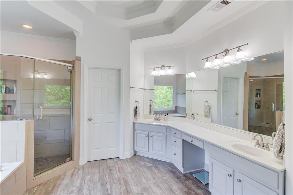 2870 Roanoke Road Cumming, GA 30041 - Photo 31 of 94 a large bathroom with a double vanity sink a large mirror a shower and a bathtub