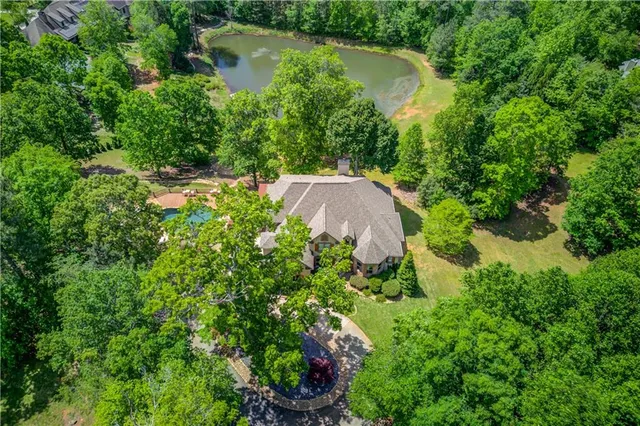a view of a dining room with furniture a chandelier and large windows