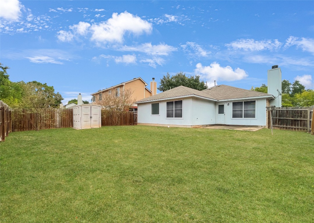 3700 Pevetoe Street Austin, TX 78725 - Photo 14 of 14 Back of house with a storage shed, a fenced backyard, a chimney, and a patio