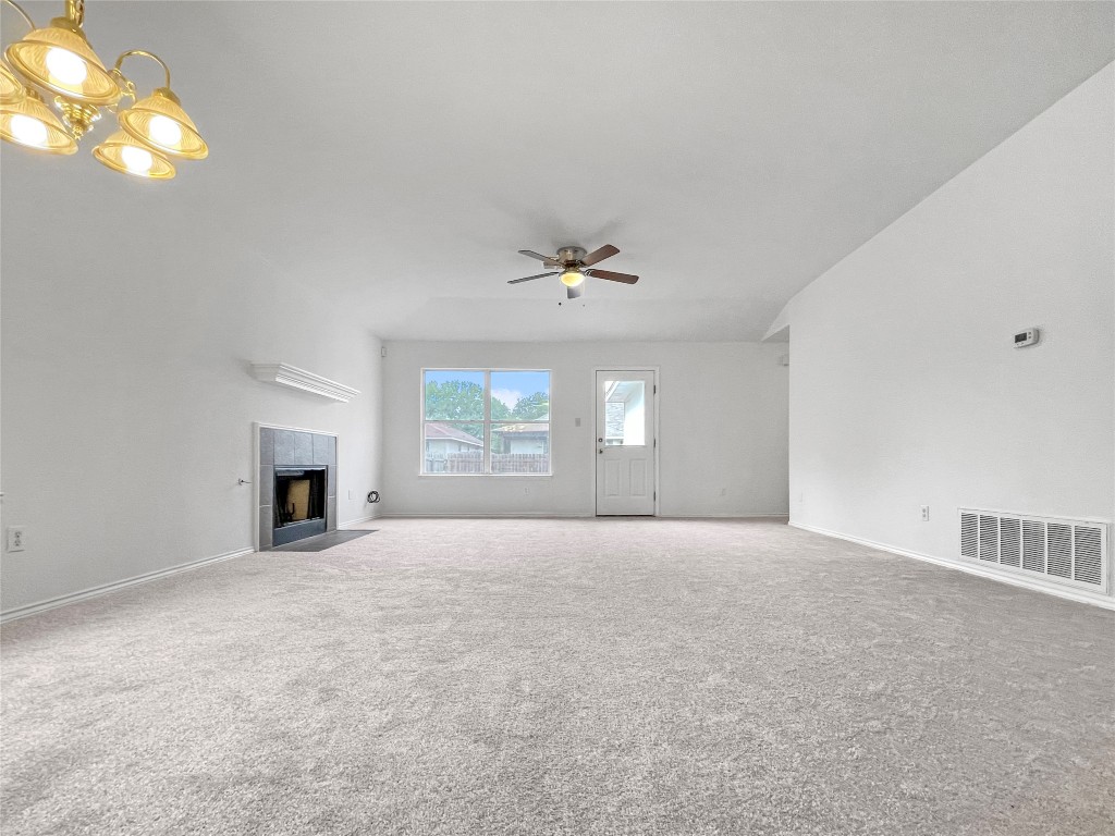 3700 Pevetoe Street Austin, TX 78725 - Photo 4 of 14 Unfurnished living room with a tiled fireplace, carpet floors, and a ceiling fan