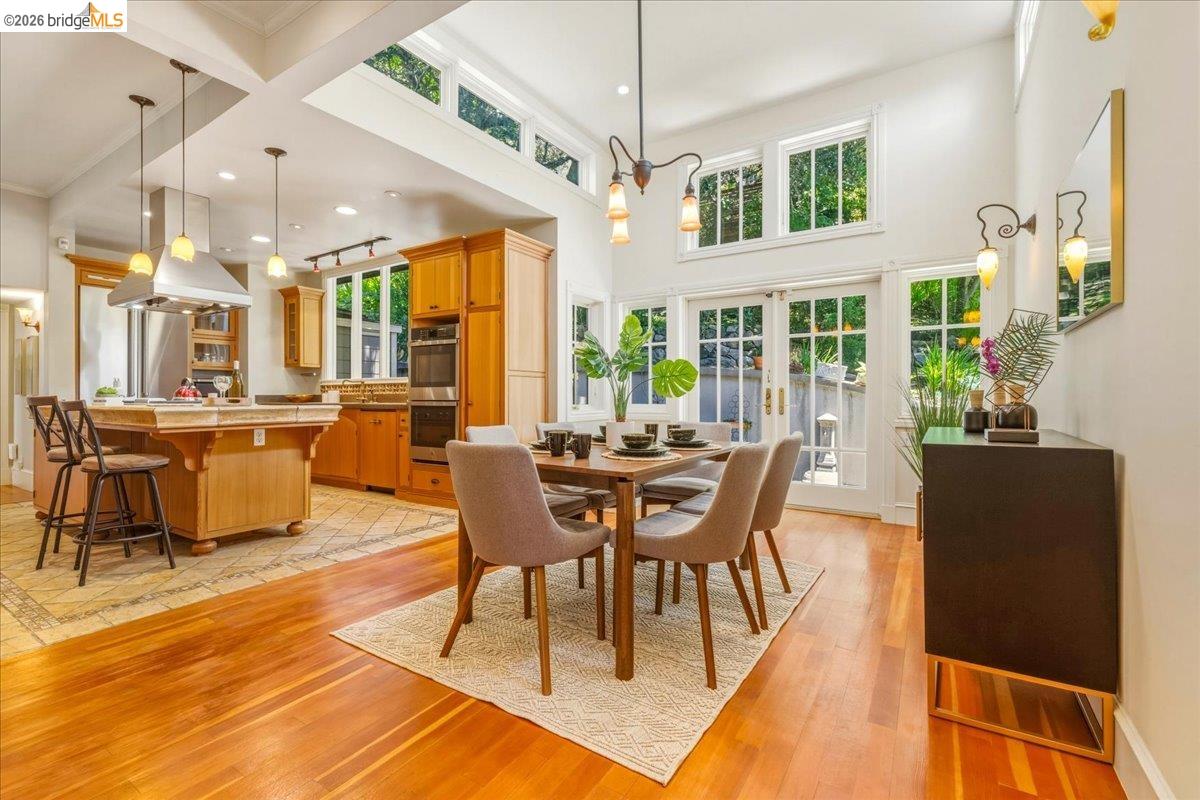 1631 La Vereda Road Berkeley, CA 94709 - Photo 12 of 42 Open-concept dining area featuring wood-finish flooring, a high vaulted ceiling, and transom windows