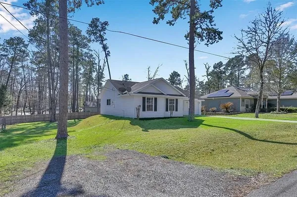 a view of a big house with a big yard and large trees