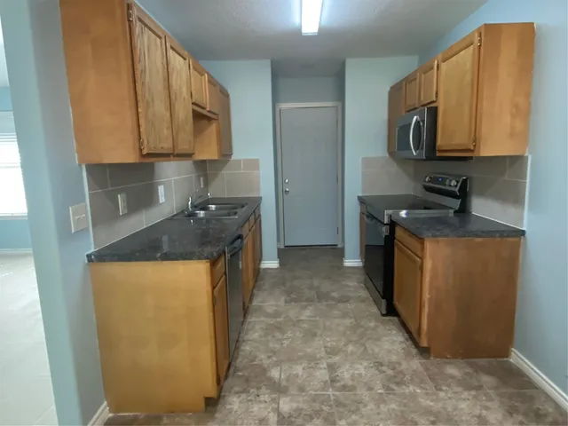 a kitchen with stainless steel appliances granite countertop a sink stove and microwave