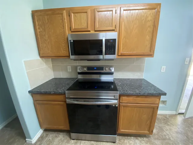 a stove top oven sitting inside of a kitchen