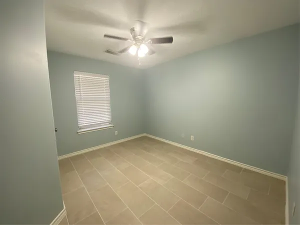 an empty room with windows and fan