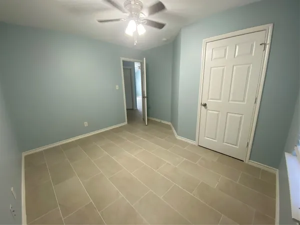 an empty room with closet and fan