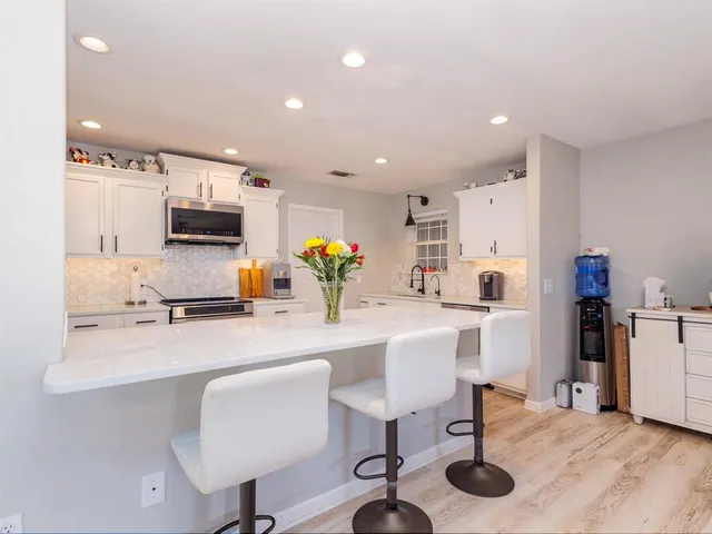 a kitchen with a sink cabinets and wooden floor